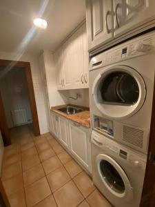 uma cozinha com uma máquina de lavar e secar roupa e um lavatório em Casa los 8 caños em Ezcaray