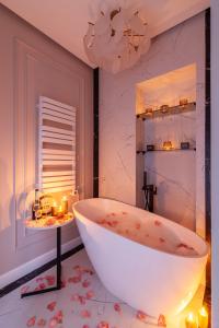 uma casa de banho com uma grande banheira branca e uma mesa em Alfa Apartments Ivana Franka em Lviv