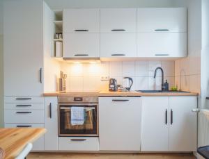 a kitchen with white cabinets and a sink at Apartment Innenstadt- Zentral und Exklusiv in Bestlage, Stilvolles Ambiente, alles zu Fuß erkunden in Braunschweig