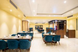 une salle à manger avec des tables et des chaises bleues dans l'établissement Bhairahawa Garden Resort, à Rummindei