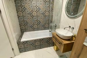 Apartament Niebieski في لودز: حمام مع حوض ودش وحوض استحمام