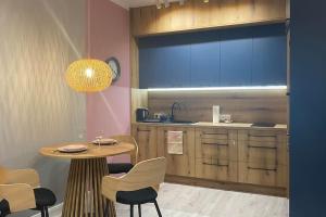 Apartament Niebieski في لودز: مطبخ مع طاولة وطاولة وكراسي