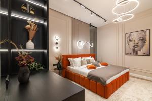 リヴィウにあるAlfa Apartments Ivana Frankaの黒い壁のベッドルーム1室(オレンジ色のベッド1台付)