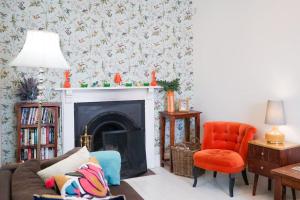 a living room with a fireplace with a couch and a chair at Heart of Totnes, Period Property in Dean