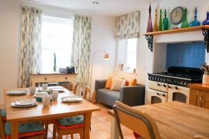 een keuken en een woonkamer met een tafel en een eetkamer bij Heart of Totnes, Period Property in Dean