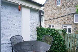 a black table and chairs in front of a building at Heart of Totnes, Period Property in Dean