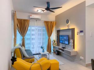 a living room with a yellow couch and a tv at Corner KL Pool View RC Residence with High Internet Speed 500Mbps in Kuala Lumpur