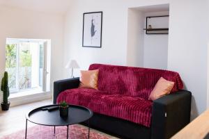 a living room with a red couch and a table at CARMEN in Serris