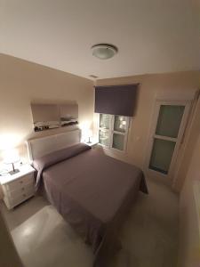 um quarto com uma cama grande e 2 janelas em Áncora apartamento em El Puerto de Santa Maria