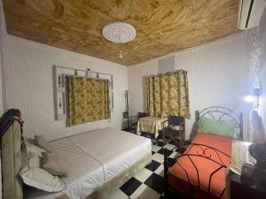 Schlafzimmer mit einem Bett und einem Tisch in der Unterkunft La Maison Traditionnelle Hôtel et guesthouse in Tafraout