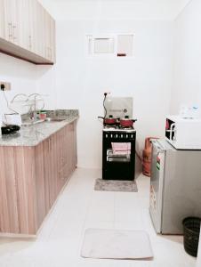 a kitchen with a stove and a refrigerator at Spacious Studio in Kileleshwa Nairobi in Nairobi