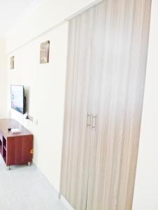 a room with a curtain and a desk and a television at Spacious Studio in Kileleshwa Nairobi in Nairobi
