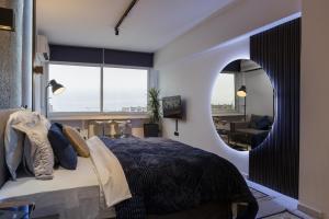 een slaapkamer met een groot bed en een spiegel bij Limani's Sea View Deluxe in Thessaloniki