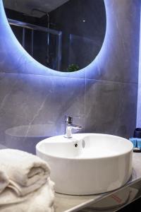 een badkamer met een witte wastafel en een spiegel bij Limani's Sea View Deluxe in Thessaloniki