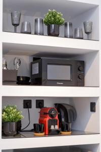 a kitchen shelf with a coffee maker and plants at Limani's Sea View Deluxe in Thessaloniki
