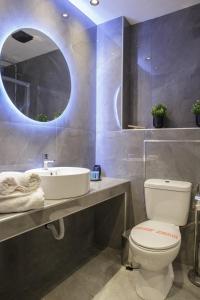een badkamer met een wastafel, een toilet en een spiegel bij Limani's Sea View Deluxe in Thessaloniki
