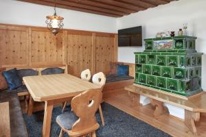a dining room with a table and a green cabinet at Klammgut in Wagrain