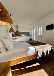 uma cama grande num quarto com uma cozinha em Fishermans House em Almograve