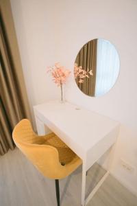 a white desk with a mirror and a yellow chair at House by the Lake 7 in Bucharest