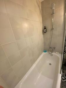 巴黎的住宿－Charming studio near Tour Eiffel Invalides Beaugrenelle，带淋浴的浴室配有白色浴缸。