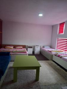 een kamer met drie bedden en een groene tafel bij Arthur 3 in Brčko
