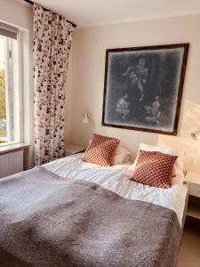 1 dormitorio con 1 cama y una pintura en la pared en Gåsen Out en Burgsvik