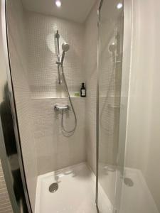 a bathroom with a shower with a glass door at Cozy studio 10 min from Eiffel Tower Invalides Beaugrenelle in Paris