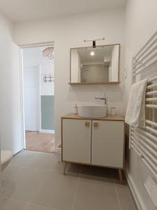 a white bathroom with a sink and a mirror at chez Clem in Calais