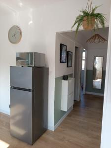 a kitchen with a refrigerator and a clock on the wall at chez Clem in Calais