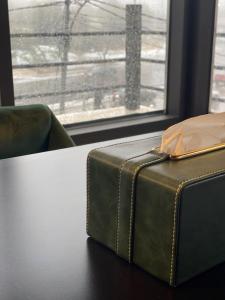 a green suitcase sitting on a table next to a window at Diamond Hotel in Amman