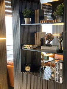 a book shelf with books and a clock on it at Diamond Hotel in Amman