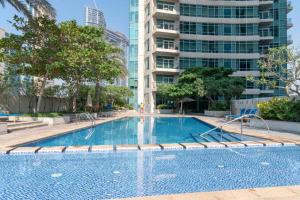 a swimming pool in a city with a tall building at Vacay Lettings - Loft Downtown Dubai in Dubai