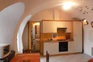 La Saulceにあるstudio du jardinの白いキャビネット付きのキッチン、アーチ型の天井