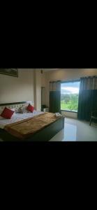 een slaapkamer met een groot bed en een raam bij Hotel Seven View Durg in Durg