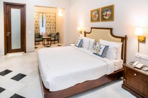 - une chambre avec un grand lit et une table dans l'établissement Chez Lavania - A Boutique Homestay, à Udaipur