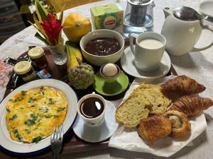 una mesa de desayuno con una tortilla y pan y café en Joli bungalow fleuri, en Les Abymes