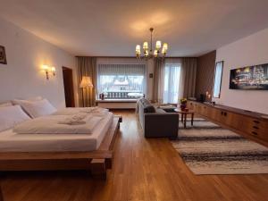 a bedroom with a large bed and a living room at Casa Ema Austria in Ramingstein