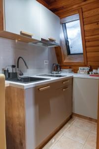 uma cozinha com um lavatório e uma janela em Vucko Apartman 405 em Jahorina