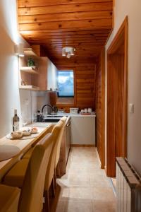 Il comprend une cuisine dotée de plafonds en bois et d'une grande table. dans l'établissement Vucko Apartman 405, à Jahorina