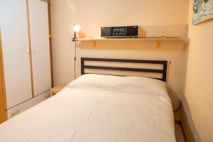 um pequeno quarto com uma cama e um rádio em SE031 - Senigallia, bilocale fronte mare al residence Piramidi em Scapezzano