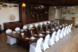 a long table and white chairs in a room at Korek Mountain Resort in Erbil