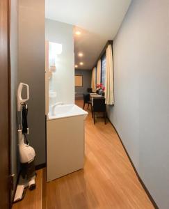 łazienka z umywalką oraz pokój ze stołem w obiekcie Tomi Home 2F w Tokio