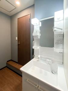 a bathroom with a white sink and a mirror at Tomi Home 2F in Tokyo