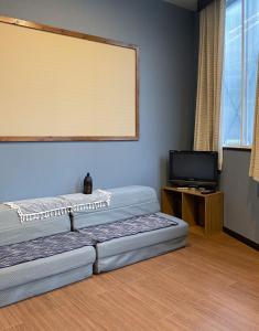 a room with two beds and a tv in it at Tomi Home 2F in Tokyo
