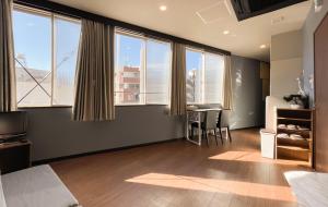 a bedroom with large windows and a table with chairs at Tomi Home 2F in Tokyo