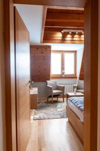 um quarto com uma cama, uma cadeira e uma janela em Vucko Apartman 405 em Jahorina