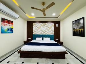 a bedroom with a bed with a ceiling fan at Kadwali Villa with Private Pool in Ujjain