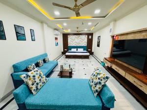 a living room with a blue couch and a bed at Kadwali Villa with Private Pool in Ujjain