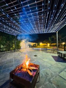 a fire pit in the middle of a patio at night at Kadwali Villa with Private Pool in Ujjain