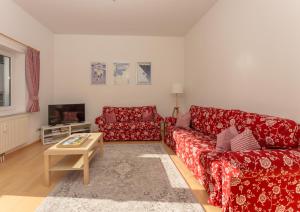 a living room with two red couches and a coffee table at Appartements Maria Stewart by Schladming-Appartements in Schladming